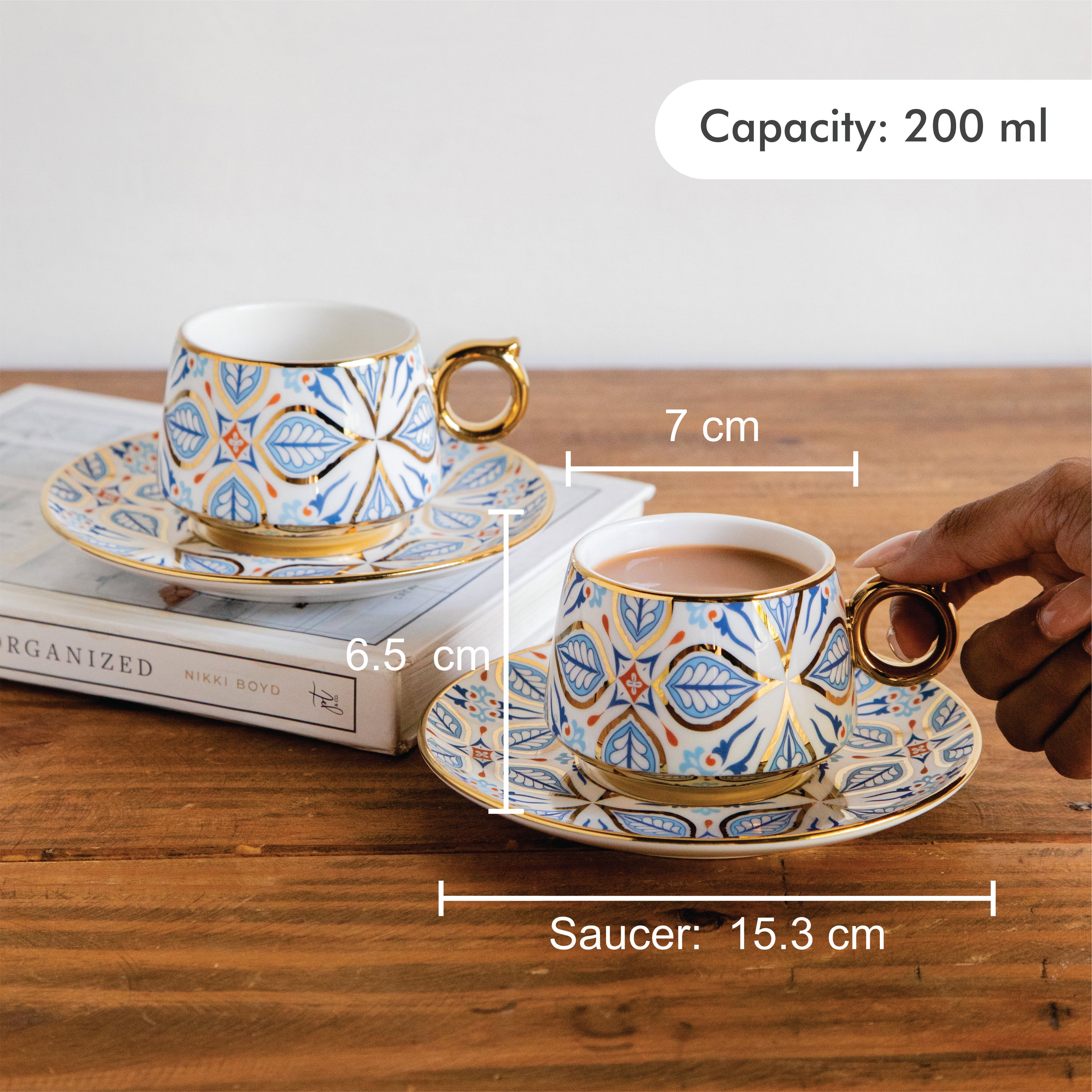 Ceramic cup and saucer set with measurements on a wooden surface